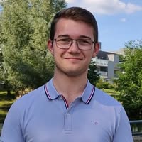 Young man smiling in park, wearing glasses