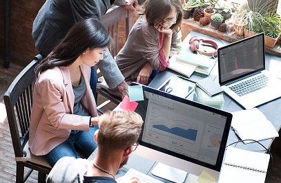 Team analyzing data on laptop in office meeting