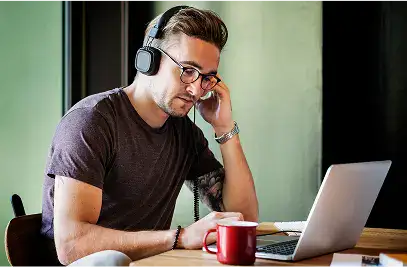 Man with headphones working on laptop at desk